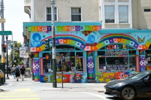 A car is parked in front of a brightly colored building