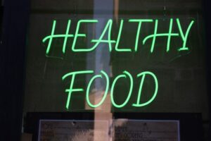 a green neon sign that says healthy food | gut health wellness routine