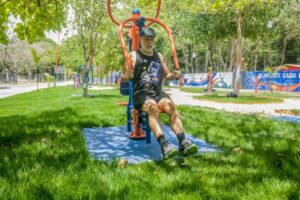 A man exercising on outdoor gym equipment in a park