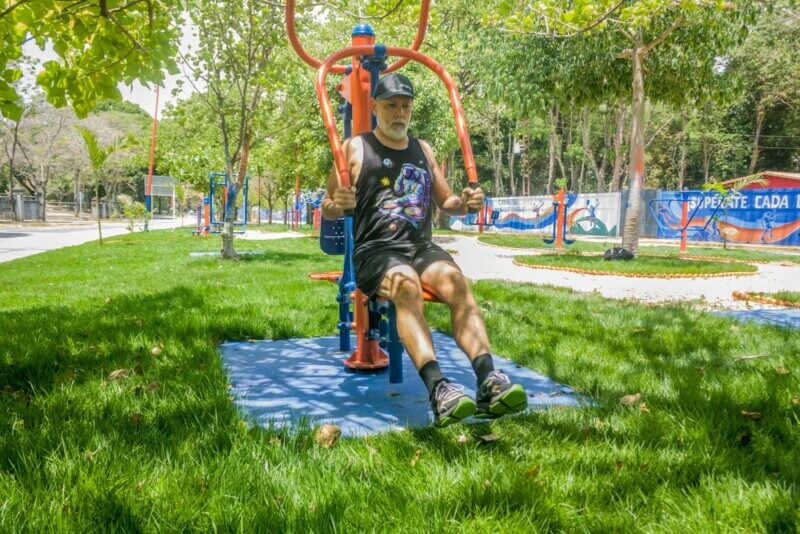 A man exercising on outdoor gym equipment in a park