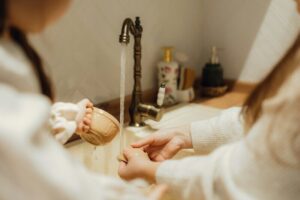 A woman in a bathrobe is putting on her foot