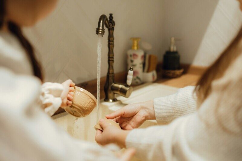 A woman in a bathrobe is putting on her foot